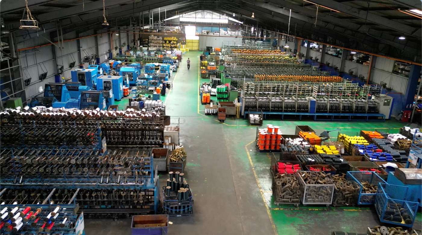 Rows of braiding machines and yarn spools running on the Jaya Nets production floor