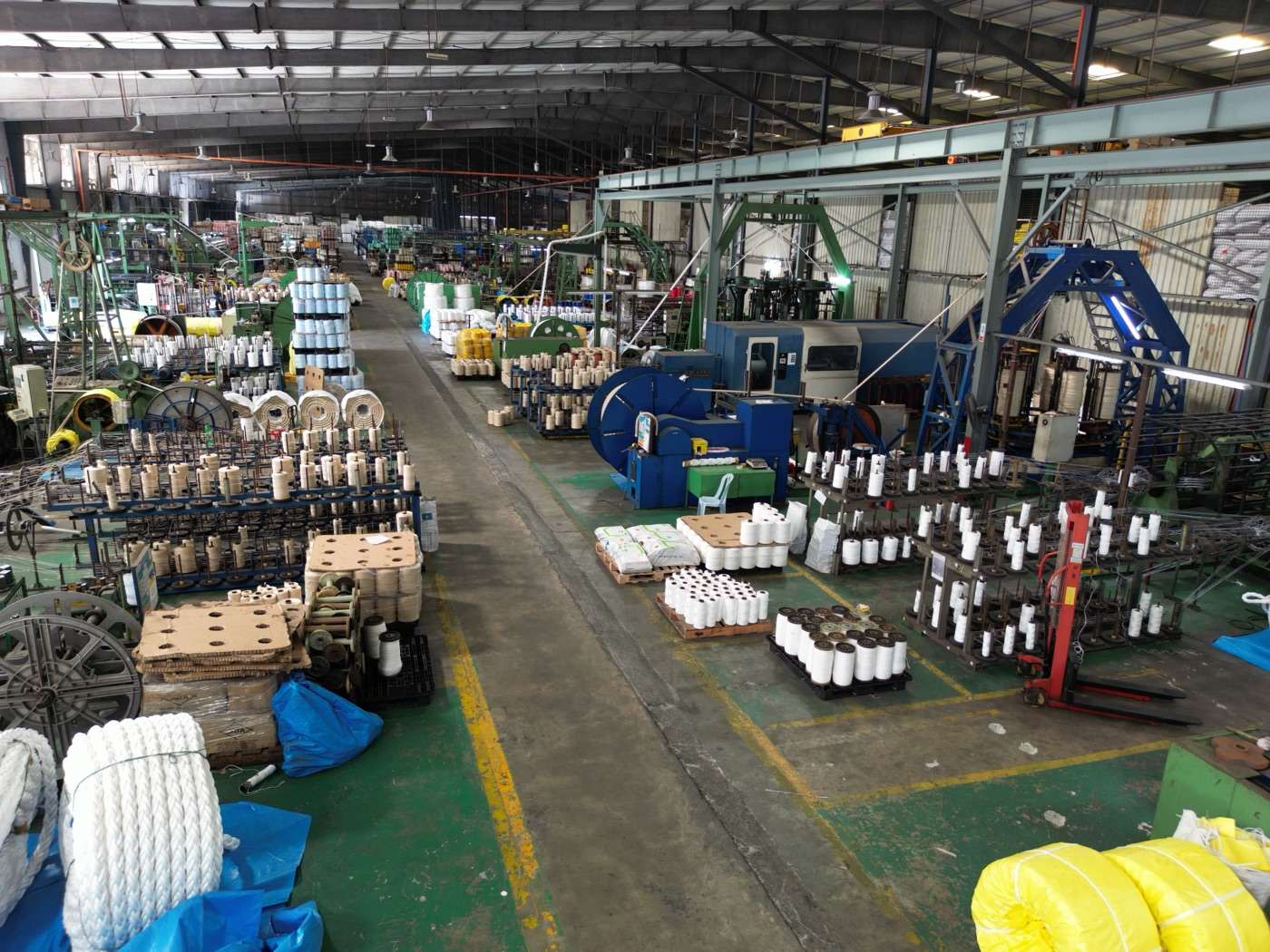 Wide view of the Jaya Nets production floor, with rope-making machines and spools of yarn