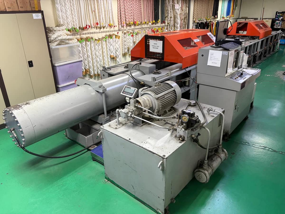 A rope under tension on a breaking-load testing machine in the Jaya Nets lab